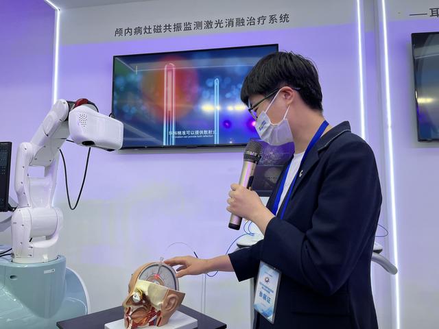 工作人員向大家介紹顱內(nèi)病灶磁共振監(jiān)測(cè)激光消融治療系統(tǒng)。宋婧 攝